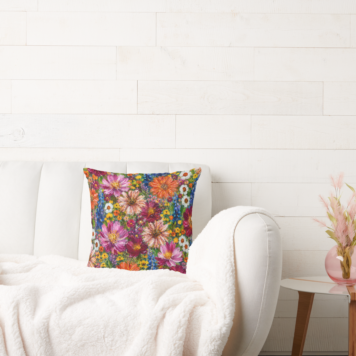 Wildflower garden throw cushion styled on a white armchair with colourful floral artwork by Nicky Bourke
